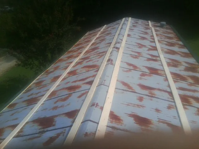 Rusted metal roof panels with new wood purlins before replacement — Storm Damage Roof Repair in Rives by Roofing Brothers