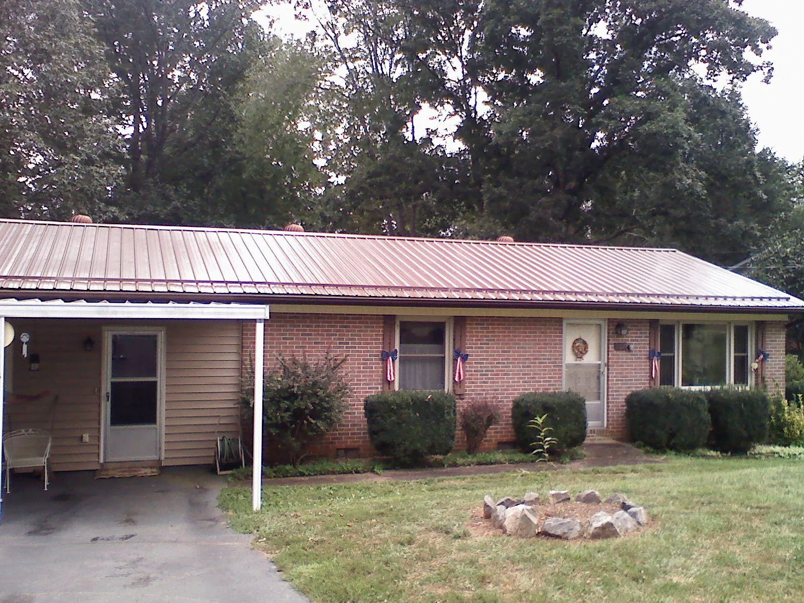 Bronze metal roof and carport on a brick ranch home — Roof Repair work by our crew in Rives