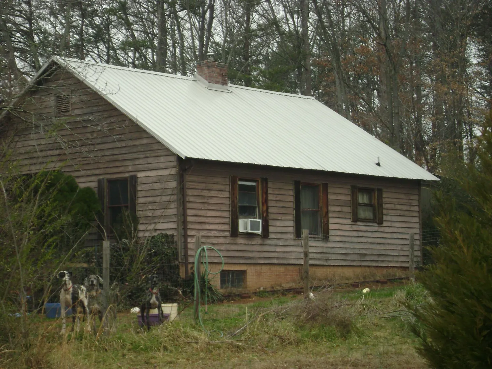 White metal roof on an old wood sided farmhouse, from a Metal Roof Installation job in Rives